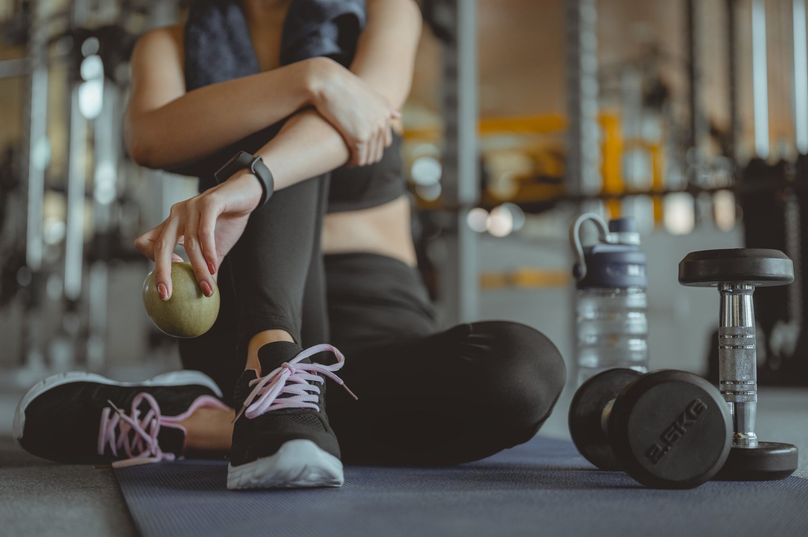 asian woman exercising in the gym, young woman workout in fitness for her healthy and office girl lifestyle. she is holding green apple. fitness ,workout, gym exercise,lifestyle and healthy concept.
